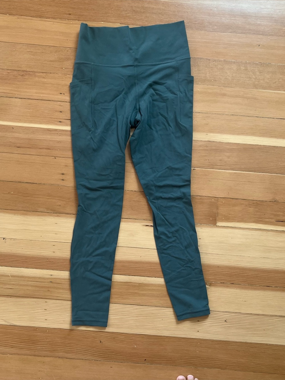Athleta salutation stash pocket 7/8 leggings in the color oasis